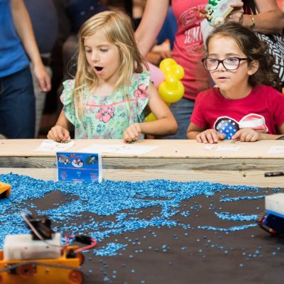 Girls learn STEM driving construction robots made by Kinvert STEM students