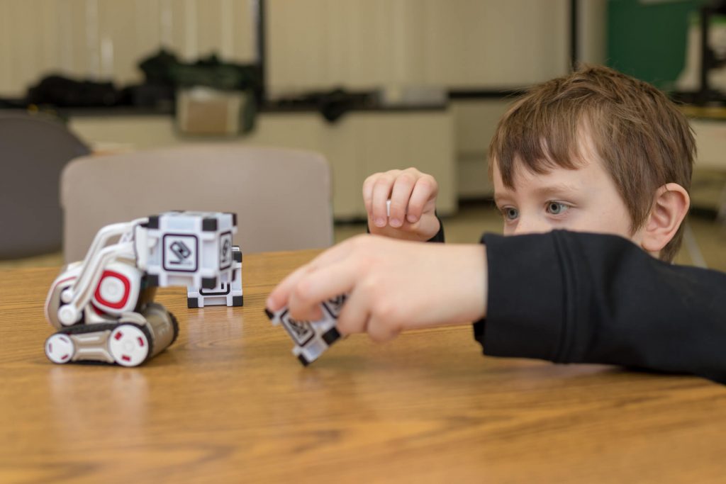 As part of our Anki Cozmo Robotics Competition Summer Camp for Kids and Teens a student interacts with Cozmo